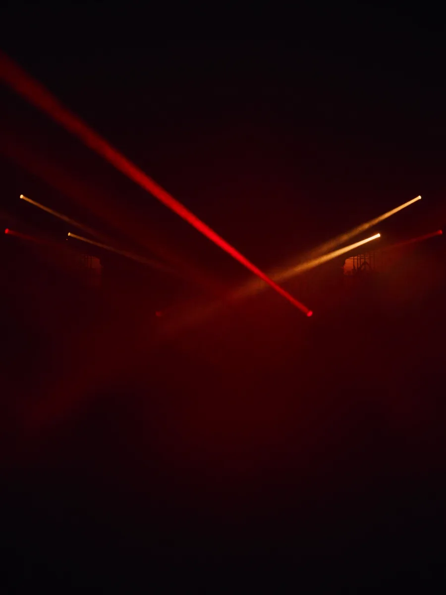 Stage light beams crossing through fog in a dark venue